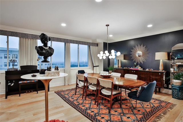 dining room featuring light hardwood / wood-style flooring, a water view, and crown molding