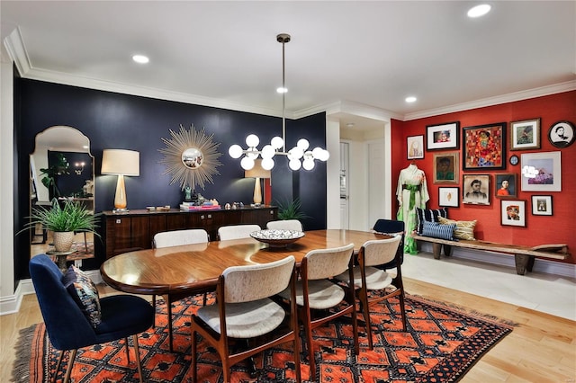 dining area with ornamental molding, light hardwood / wood-style floors, and a chandelier