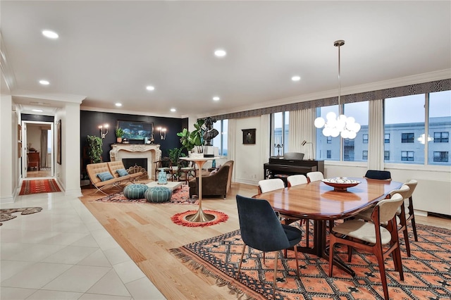 dining space with a chandelier, light wood-type flooring, and crown molding