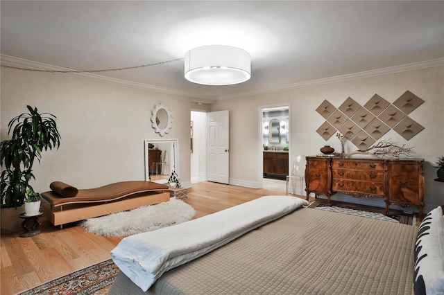 bedroom featuring wood-type flooring, ensuite bath, and crown molding