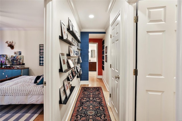 hallway with ornamental molding and light hardwood / wood-style floors