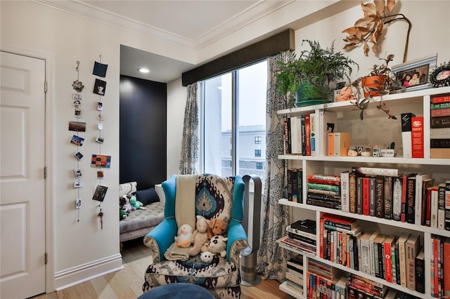 sitting room with hardwood / wood-style flooring and ornamental molding