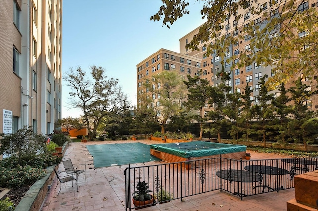 view of pool featuring a jacuzzi and a patio