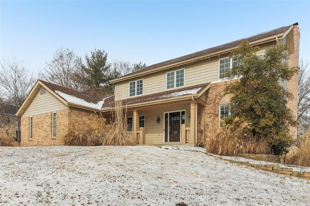 traditional home featuring brick siding and a chimney