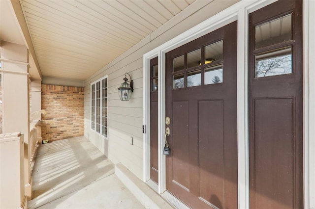 view of exterior entry featuring brick siding