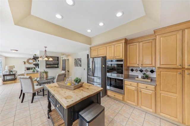 kitchen featuring a kitchen island, appliances with stainless steel finishes, open floor plan, and light tile patterned flooring