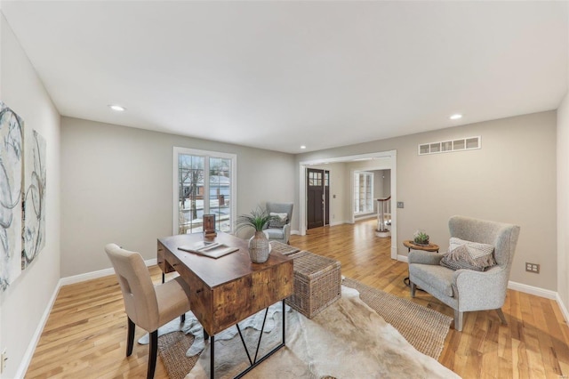 dining space with baseboards, visible vents, and light wood-style floors