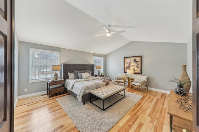 bedroom featuring light wood finished floors, ceiling fan, baseboards, and vaulted ceiling