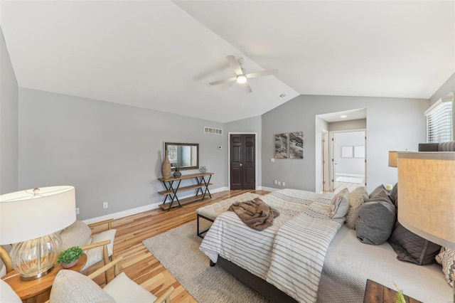 bedroom with lofted ceiling, wood finished floors, a ceiling fan, visible vents, and baseboards