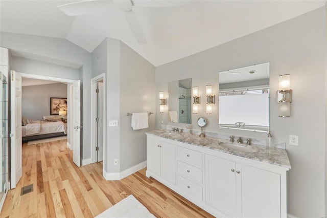 full bath featuring lofted ceiling, wood finished floors, ensuite bathroom, a shower stall, and a sink