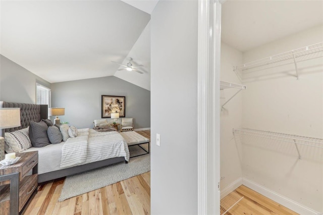 bedroom featuring ceiling fan, vaulted ceiling, baseboards, and wood finished floors