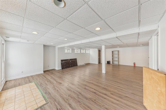 below grade area featuring visible vents, baseboards, wood finished floors, a paneled ceiling, and recessed lighting