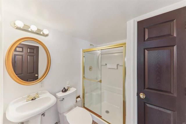 bathroom with a sink, a shower stall, and toilet