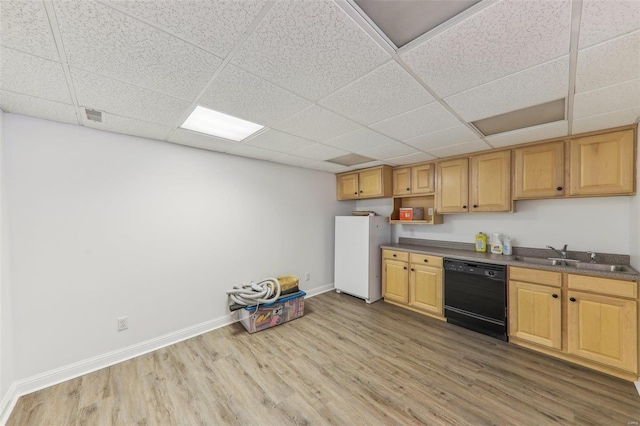 kitchen with black dishwasher, dark countertops, freestanding refrigerator, a sink, and wood finished floors