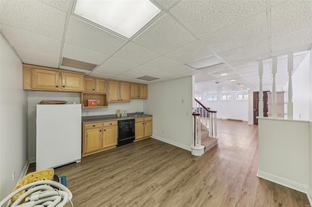 kitchen with black dishwasher, baseboards, dark countertops, wood finished floors, and freestanding refrigerator