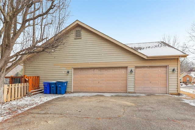 snow covered garage with a garage