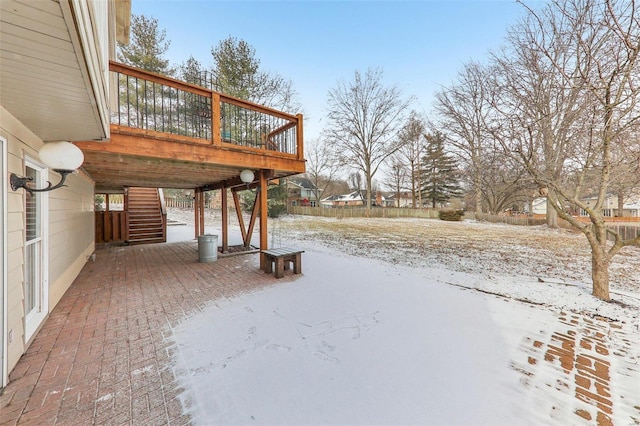 yard layered in snow with stairs and a wooden deck