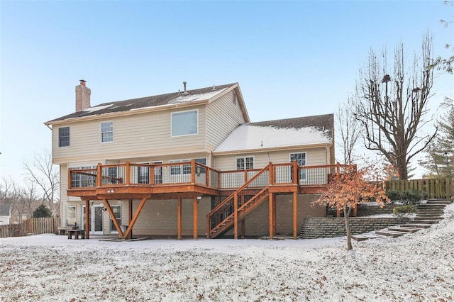 snow covered house featuring stairs, a chimney, a deck, and fence