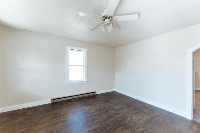 spare room featuring dark wood-type flooring, ceiling fan, and baseboard heating