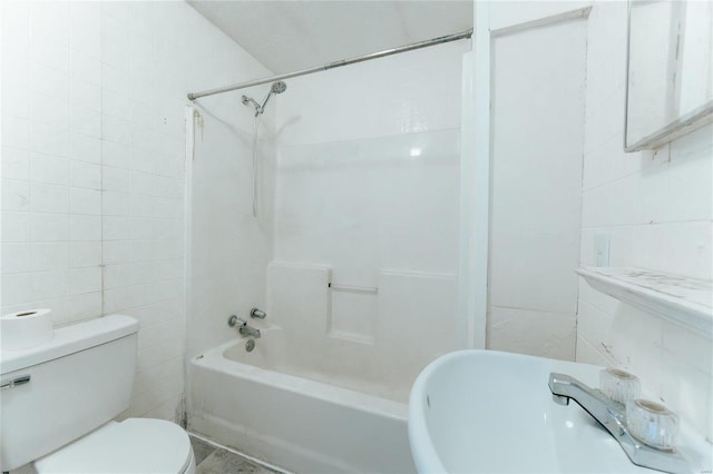 bathroom with toilet, tile walls, and shower / bathtub combination