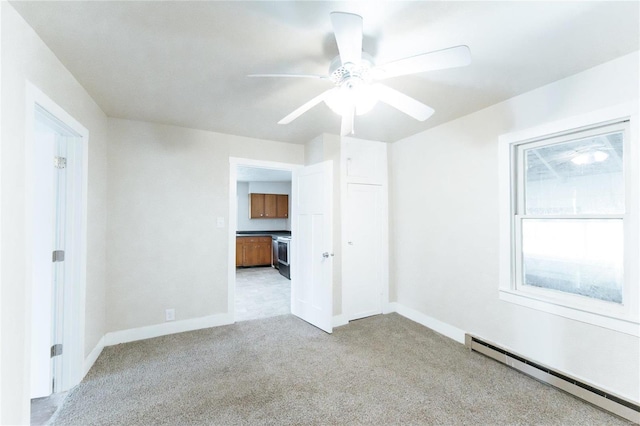 carpeted empty room featuring ceiling fan and a baseboard radiator