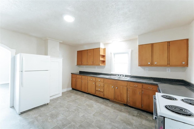 kitchen with sink, a textured ceiling, and white appliances