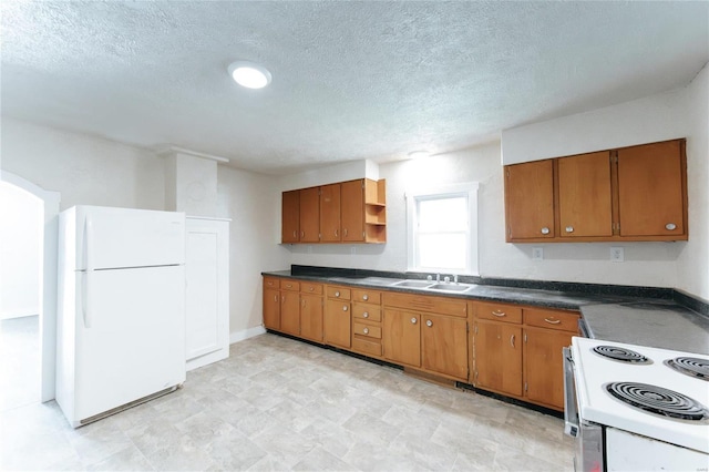 kitchen with sink, a textured ceiling, and white appliances