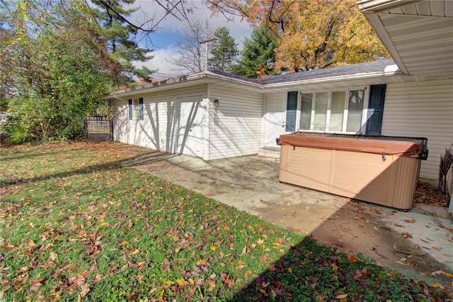 exterior space with a hot tub, a patio area, and a yard