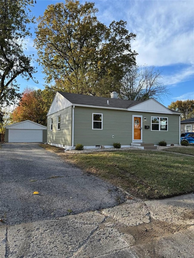 view of front facade featuring a garage, an outdoor structure, and a front lawn