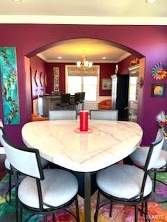 dining area featuring ornamental molding and an inviting chandelier