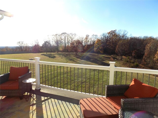 wooden terrace with a rural view and a yard