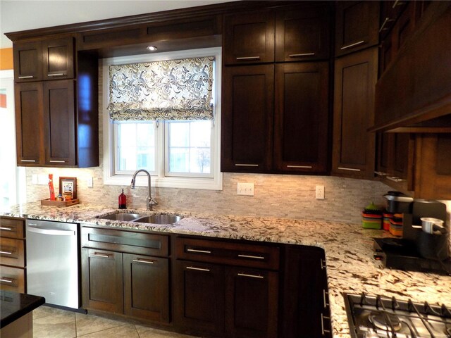 kitchen with stainless steel appliances, light stone countertops, sink, and backsplash