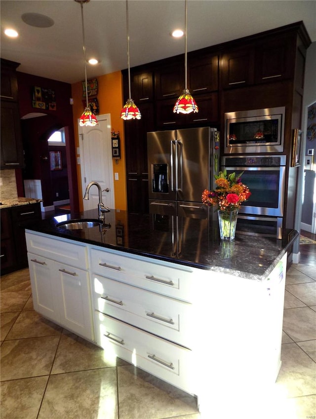 kitchen with stainless steel appliances, white cabinetry, dark brown cabinetry, pendant lighting, and sink