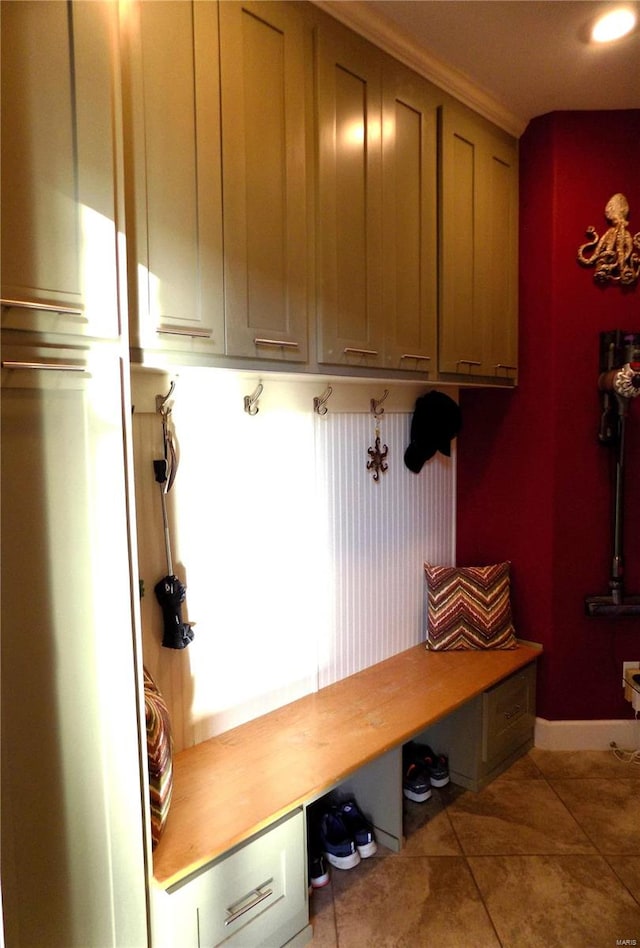 mudroom featuring light tile patterned floors and crown molding