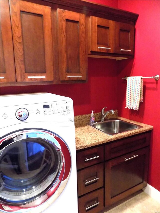 washroom with cabinets, washer / clothes dryer, and sink