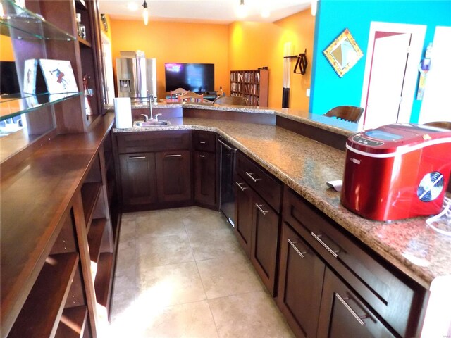 bar with dark brown cabinetry, sink, light tile patterned flooring, stone countertops, and wine cooler