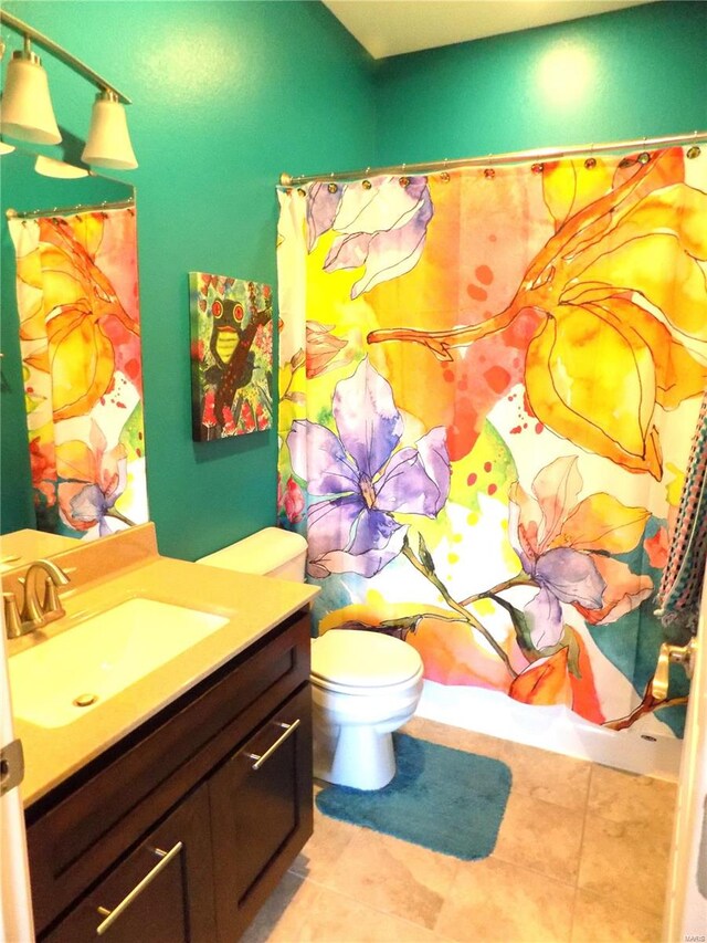 bathroom featuring toilet, vanity, and tile patterned flooring