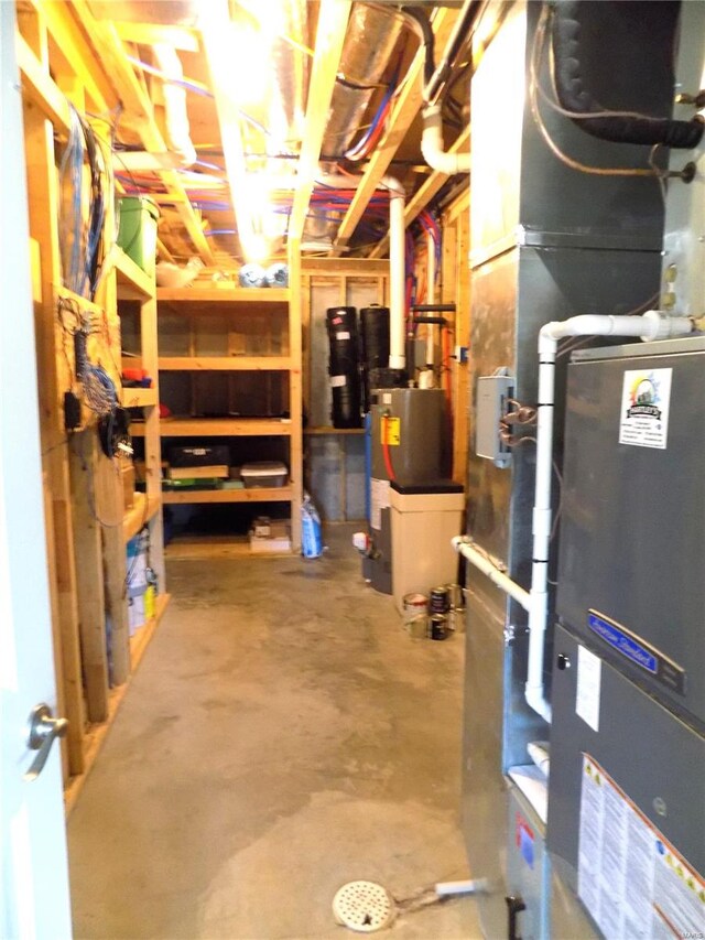 basement featuring water heater and heating unit