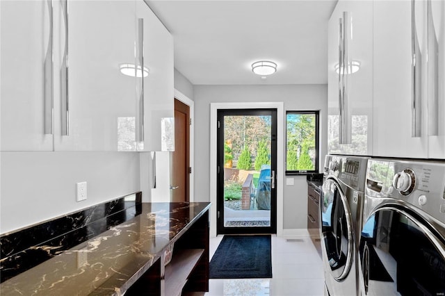 laundry area featuring washing machine and clothes dryer and tile patterned floors