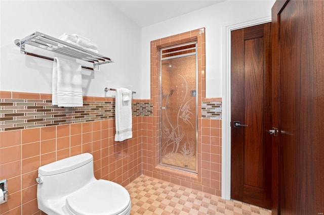 bathroom featuring a shower, tile patterned flooring, toilet, and tile walls