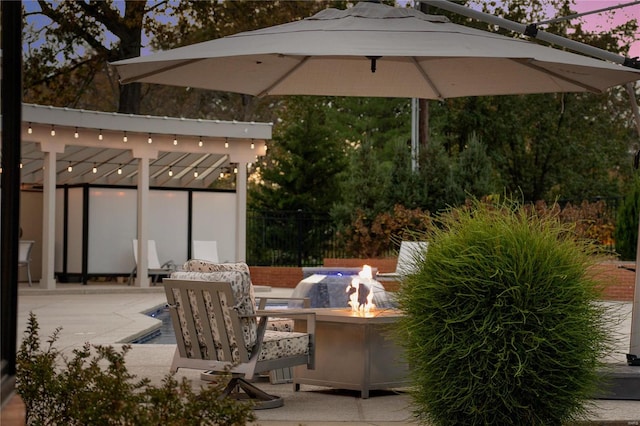 patio terrace at dusk featuring an outdoor fire pit