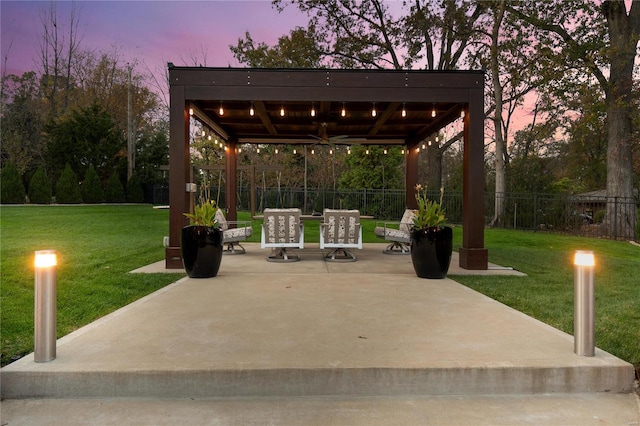 patio terrace at dusk featuring a yard