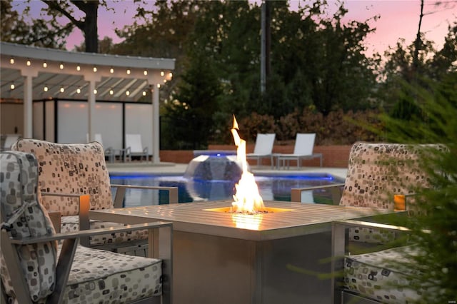 pool at dusk featuring pool water feature, exterior bar, and a patio