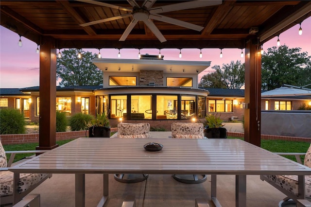 back house at dusk with a gazebo and ceiling fan