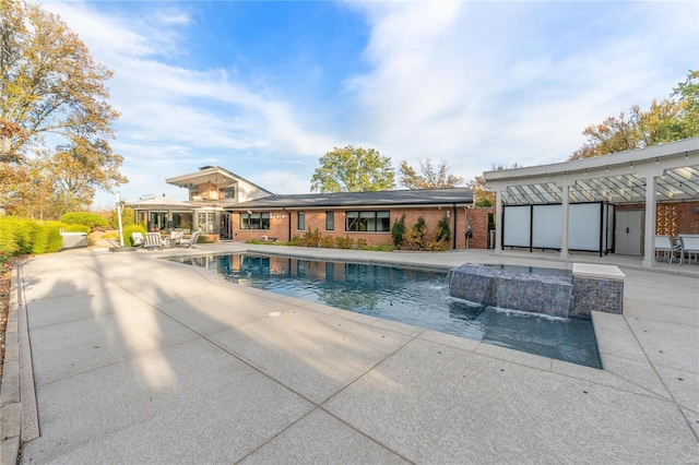 view of swimming pool featuring pool water feature, a patio area, and a hot tub