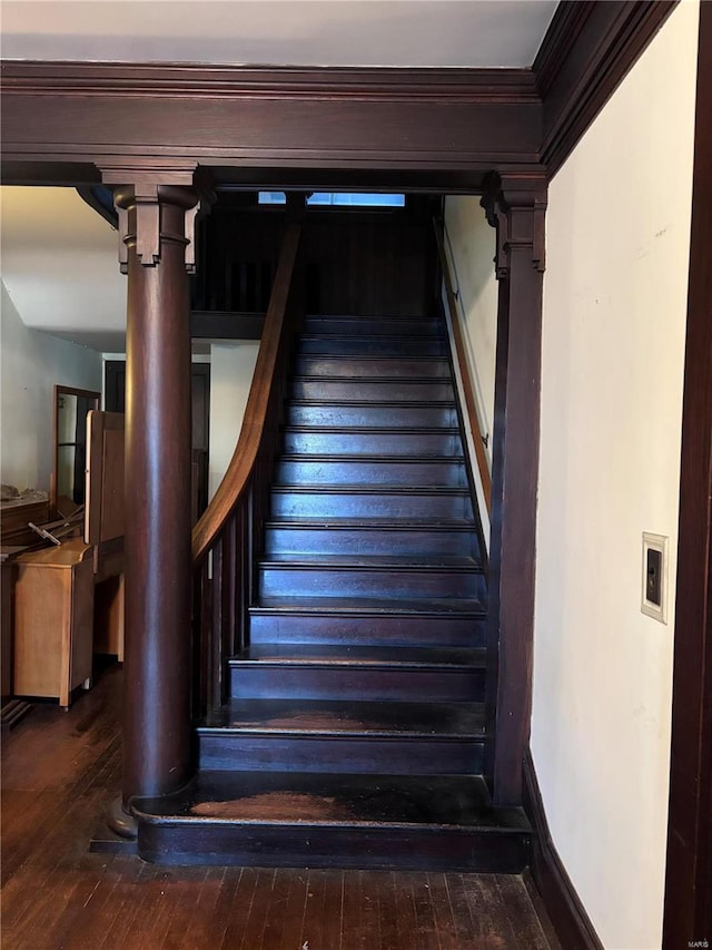 stairs featuring ornamental molding and wood-type flooring