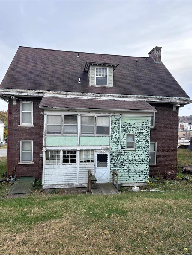 rear view of property with a lawn