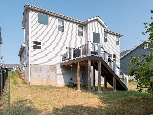 back of property with a deck and a yard