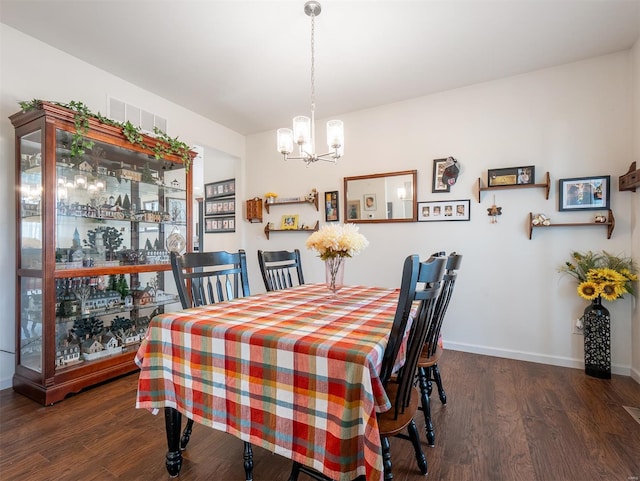 dining room featuring dark hardwood / wood-style flooring and a notable chandelier