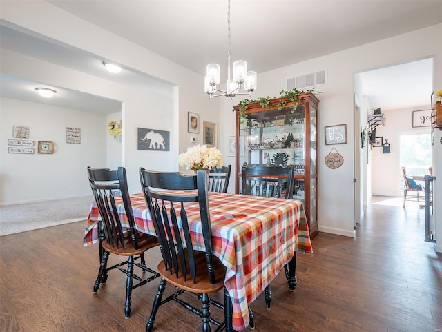 dining room featuring dark hardwood / wood-style flooring and a chandelier